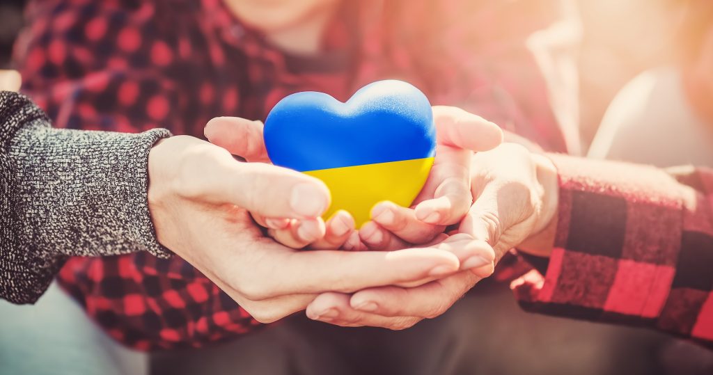 Family hands holding a heart in Ukrainian colors. Peace and no war concept